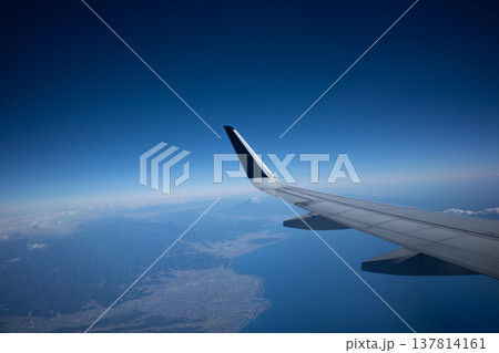 飛行機の翼と青空、遠くに見える富士山と海岸線の街並み 飛行機の翼と青空、遠くに見える富士山と海岸線の街並み 137814161