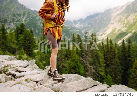 Close-up of female legs in hiking boots on a hiking trail. Travel, vacation. The concept of nature. 137814740