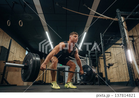 No pain, no gain, weightlifting. Athletic man is with a barbell in a gym 137814821