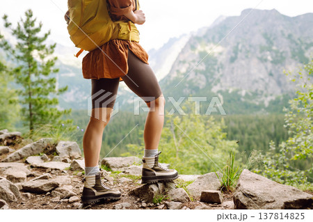 Close-up of female legs in hiking boots on a hiking trail. Travel, vacation. The concept of nature. Close-up of female legs in hiking boots on a hiking trail. Travel, vacation. The concept of nature. 137814825