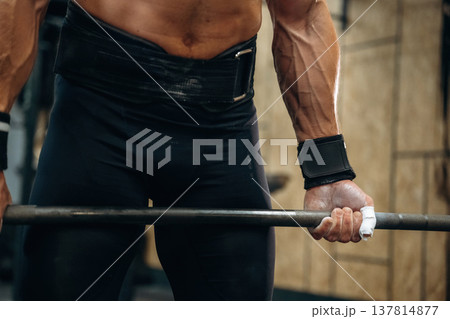 Strength and stamina. Close up view of athletic man that is lifting heavy barbell Strength and stamina. Close up view of athletic man that is lifting heavy barbell 137814877