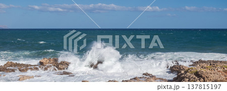 Furious storm and white foam turquoise waves crashing on rocky coast. 137815197