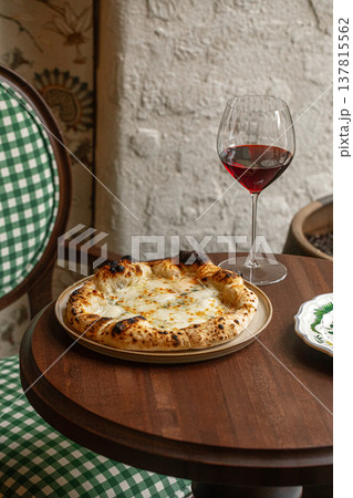 Four cheese pizza with red wine on table Four cheese pizza with red wine on table 137815562