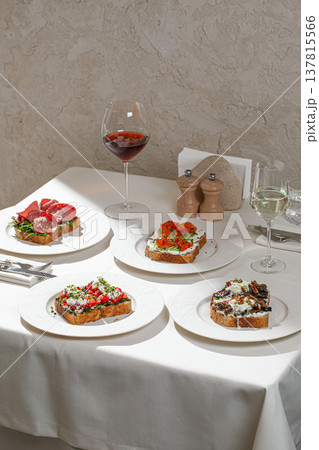 Assorted gourmet bruschetta with wine on table Assorted gourmet bruschetta with wine on table 137815566