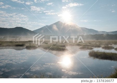 朝陽が白く輝き朝霧がたなびく池塘の水鏡に映る早朝の尾瀬ヶ原と燧ヶ岳 朝陽が白く輝き朝霧がたなびく池塘の水鏡に映る早朝の尾瀬ヶ原と燧ヶ岳 137816077