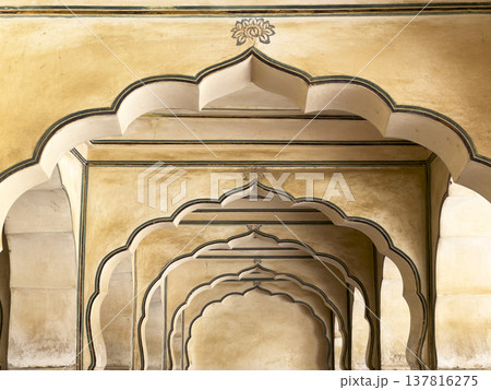 Jaipur palace corridor features repeating sandstone arch with ornate carving and symmetry. Historic Jaipur palace corridor features repeating sandstone arch with ornate carving and symmetry. Historic 137816275