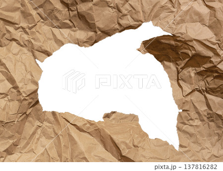 Large irregular hole rips through brown kraft paper with crumpled textured surface. Jagged torn Large irregular hole rips through brown kraft paper with crumpled textured surface. Jagged torn 137816282