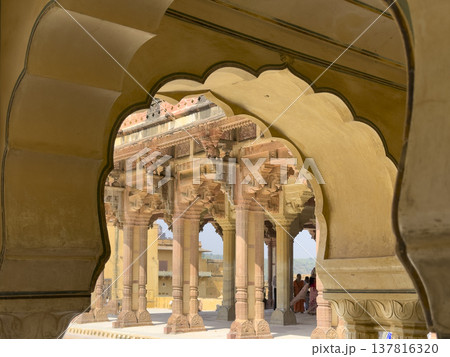 Ornate sandstone arch frames palace courtyard with carved column and decorative facade in Jaipur. 137816320