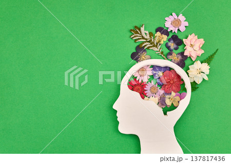 Human brain outline with fresh flowers on green Human brain outline with fresh flowers on green 137817436
