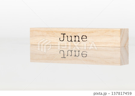 a wooden cube with the inscription June on a white background a wooden cube with the inscription June on a white background 137817459