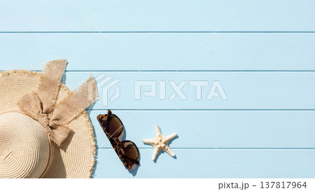 水色の木製テーブルに並べた夏のビーチ小物のフラットレイ 137817964