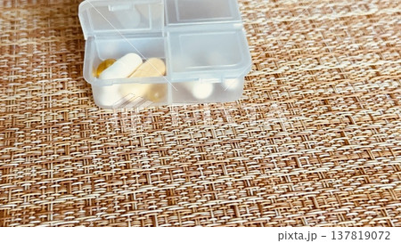 The weekly transparent pillbox is designed for convenient and efficient daily storage of dietary supplements and tablets. It has compartments with various types of capsules for administration. 137819072