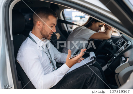 Disappointed, failure. Woman is with instructor in car, driving school concept Disappointed, failure. Woman is with instructor in car, driving school concept 137819567
