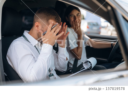 Man is mad, disappointed. Woman is with instructor in car, driving school concept 137819578