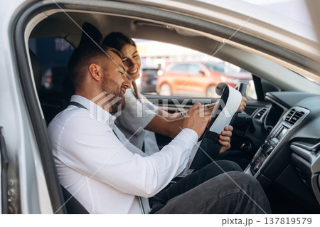 Positive mood, smiling. Woman is with instructor in car, driving school concept Positive mood, smiling. Woman is with instructor in car, driving school concept 137819579
