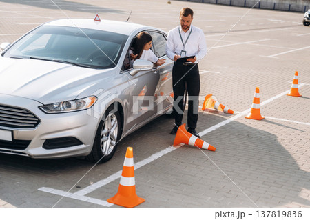 Hit the cones. Woman is trying to pass exam in the driving school Hit the cones. Woman is trying to pass exam in the driving school 137819836
