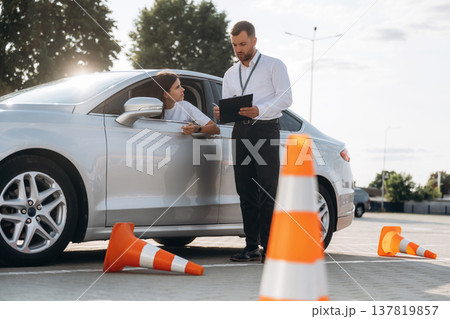 Recording the results into notepad. Woman is trying to pass exam in the driving school 137819857