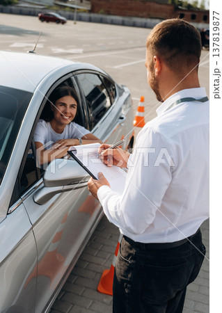 Using pen and writing results into notepad. Woman is trying to pass exam in the driving school Using pen and writing results into notepad. Woman is trying to pass exam in the driving school 137819877