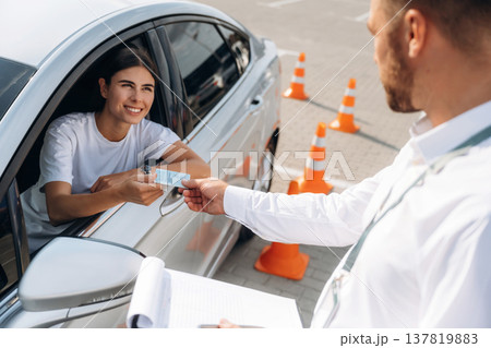 Congratulations giving the license, passed. Woman is trying to pass exam in the driving school 137819883