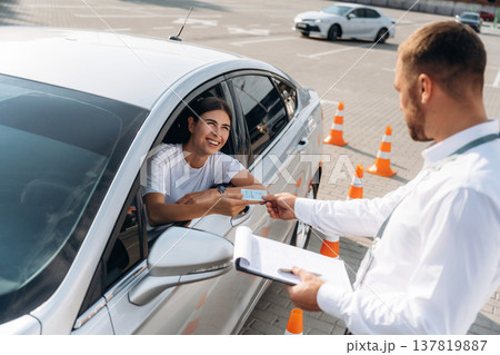 Congratulations giving the license, passed. Woman is trying to pass exam in the driving school Congratulations giving the license, passed. Woman is trying to pass exam in the driving school 137819887
