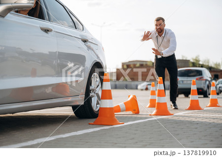 Helping to park the car. Woman is trying to pass exam in the driving school 137819910