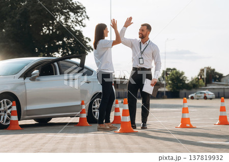 High five, you passed. Woman is trying to pass exam in the driving school High five, you passed. Woman is trying to pass exam in the driving school 137819932
