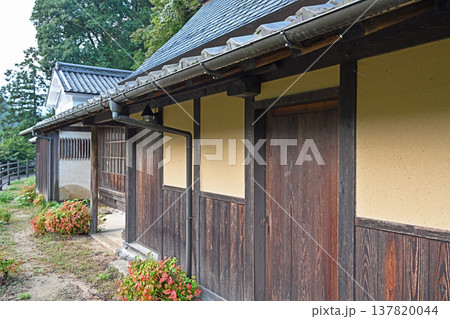 伝統的な土壁と焼杉の板張りが美しい古民家の風情ある軒下風景 137820044