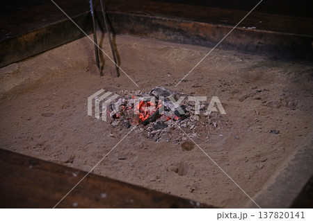 囲炉裏の灰の中で赤く熾る炭火と古民家が醸し出す安らぎに満ちた伝統的な和の空間 137820141