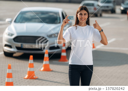 Passed the exam. Happy woman is holding her driving license, driving school test passed 137820242