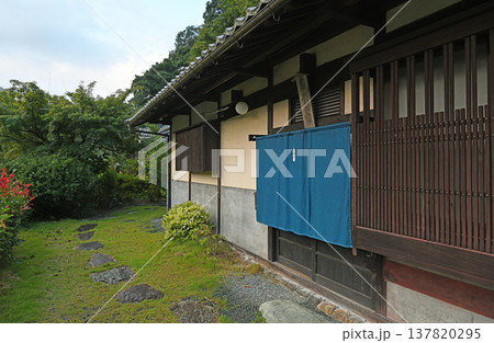 藍色の暖簾と美しい格子戸が旅人を迎える山あいの静かな古民家の玄関先風景 藍色の暖簾と美しい格子戸が旅人を迎える山あいの静かな古民家の玄関先風景 137820295