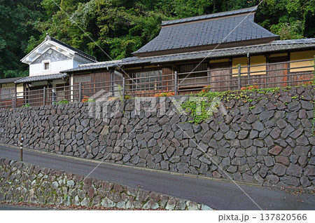 悠久の時を感じさせる重厚な石垣と兜造りの屋根が美しい里山の伝統的な建築風景 悠久の時を感じさせる重厚な石垣と兜造りの屋根が美しい里山の伝統的な建築風景 137820566
