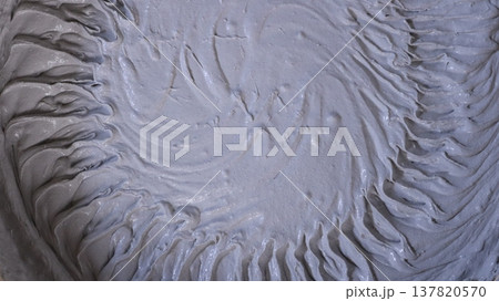 thick gray mortar with a circular ribbed pattern on a soft surface, creating an abstract textured empty background, is a mixture of building materials such as putty or plaster with a beautiful texture 137820570