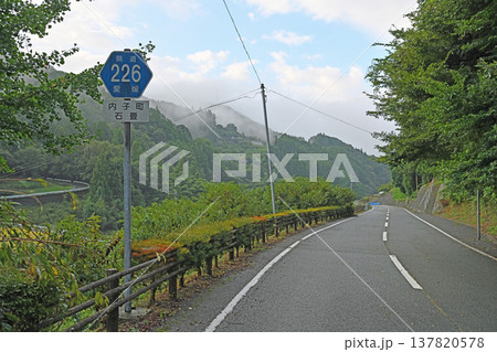 朝霧に包まれた山あいの県道を走る旅路と内子町石畳地区の静かな里山風景 137820578
