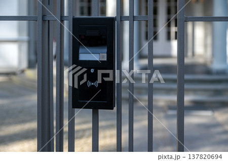 Door entry system at a gate with access control near a building during daylight hours Door entry system at a gate with access control near a building during daylight hours 137820694