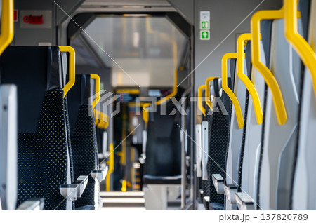 Interior of a train showing empty seats with yellow handrails Interior of a train showing empty seats with yellow handrails 137820789