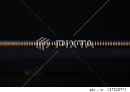 Extreme Macro Close-Up of a Metallic Winding Guitar String on a Dark Background Extreme Macro Close-Up of a Metallic Winding Guitar String on a Dark Background 137820793
