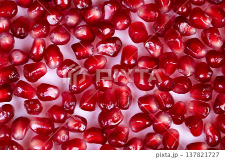Vivid berry details. Highcontrast image displaying shining red seeds with droplets. Intimate view of polished pomegranate seeds adorned with sparkling juice beads and pattern 137821727
