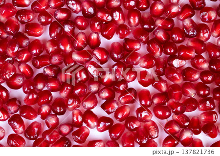 Jewelrylike fruit adornment. Closeup of luxurious pomegranate seed decoration. Magnificent presentation of glistening pomegranate seeds designed for upscale food packaging Jewelrylike fruit adornment. Closeup of luxurious pomegranate seed decoration. Magnificent presentation of glistening pomegranate seeds designed for upscale food packaging 137821736