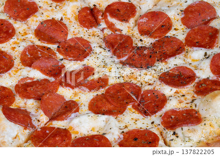 Closeup of cheesy pepperoni slice. Handheld pizza slice with salty pepperoni in social setting. Closeup of melting cheese and spicy pepperoni for group sharing event Closeup of cheesy pepperoni slice. Handheld pizza slice with salty pepperoni in social setting. Closeup of melting cheese and spicy pepperoni for group sharing event 137822205