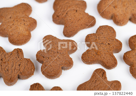 Batch of cookies prepared for sorting and packaging. Identical cookiesly arranged on plain background suggest largescale batch processing with consistent appearance 137822440