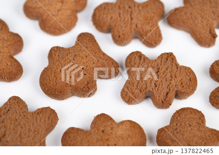 Festive cookie display. Arrangement of spiced cookies creating festive holiday snack scene. Scattered warm brown cookies evoke cozy seasonal celebration with aromatic spices 137822465