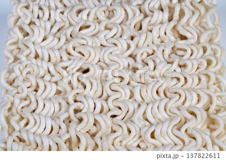 Uncooked noodle details. Closeup of dry curly ramen. Detailed view of uncooked wavy ramen strands. Highresolution image showing original dry curly ramen noodles Uncooked noodle details. Closeup of dry curly ramen. Detailed view of uncooked wavy ramen strands. Highresolution image showing original dry curly ramen noodles 137822611