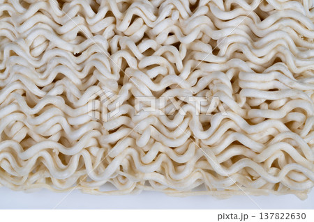 Factory dry instant noodles sample focusing on uniformity and strand formation, neutral lighting emphasizes production quality, texture irregularities and raw flour traces visible 137822630