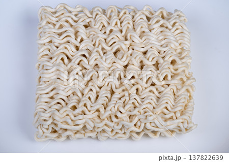 White background showcasing neatly arranged dry instant noodles package. Studio shot of compact square dry instant noodles with balanced illumination and clear focus 137822639