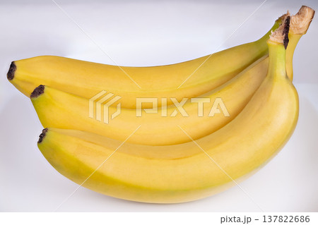 Ripe bananas bunch on clean white background, even studio lighting, shadow separation for product listing and menu imagery, focus on shape and color for commercial use 137822686