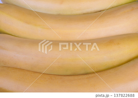 Ripe bananas closeup textured yellow skin, subtle brown freckles, soft matte sheen, tight crop emphasizing curvature and natural pattern, vivid food photography mood 137822688