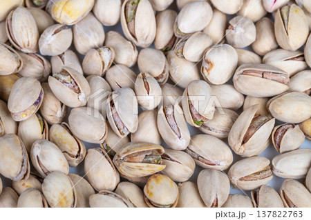 Rustic pistachio ingredient display. Closeup of pistachio shells and kernels in rustic style. Artisanal presentation of pistachio shells and kernels in natural earthy hues Rustic pistachio ingredient display. Closeup of pistachio shells and kernels in rustic style. Artisanal presentation of pistachio shells and kernels in natural earthy hues 137822763
