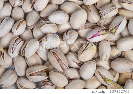 Display of raw pistachios highlighting farmfresh and eco friendly qualities. Collection of pale shells with green kernels showcasing natural and sustainable food principles 137822765