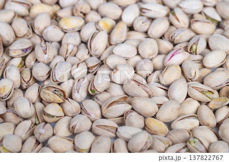 Close view of pistachios emphasizing comfort and natural colors. Detailed image showcasing pistachio shells and kernels with inviting warm tones for lifestyle themes 137822767