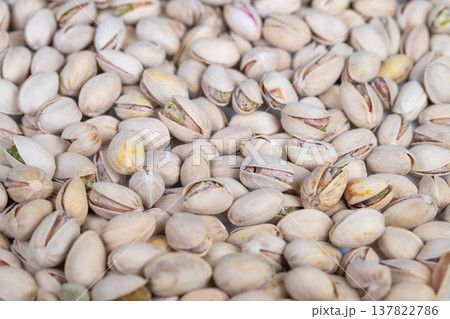 Topdown pistachios arranged for culinary preparation, raw green kernels peeking from pale shells, ideal ingredient shot for baking, confectionery and cheffocused content 137822786